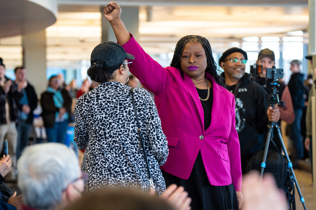 Nekima Levy Armstrong holds up her fist after speaking at an anti-ICE rally for Martin Luther King Jr.