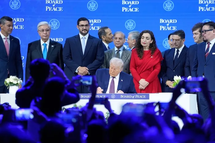 US President Donald Trump signs the charter of his Board of Peace initiative at the Annual Meeting of the World Economic Forum in Davos, Switzerland, Thursday, Jan. 22, 2026. (AP Photo/Markus Schreiber)