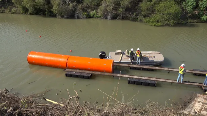 Construction crews install the first buoys in the Rio Grande, which divides the United States and Mexico.