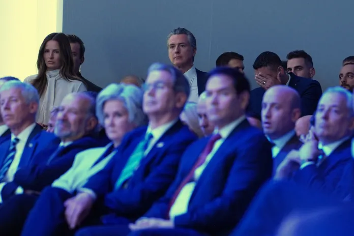 Gov. Gavin Newsom (D-CA), center rear, listens to the address of President Donald Trump during the Annual Meeting of the World Economic Forum in Davos, Switzerland, Wednesday, Jan. 21, 2026. (AP Photo/Evan Vucci)