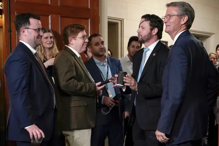 Rep. Dan Crenshaw, R-Texas, second to right, talks to reporters as the Republican caucus meets on Capitol Hill Tuesday, Oct. 24, 2023, in Washington. At very right is Rep. Tim Burchett.