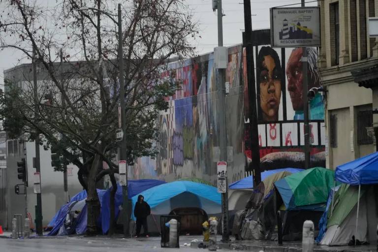 People suffering from homelessness set large tents next to the Emmanuel Baptist Rescue Mission on Monday, Feb. 5, 2024, in Los Angeles. A storm of historic proportions dumped a record amount of rain over parts of Los Angeles on Monday, sending mud and boulders down hillsides dotted with multimillion-dollar homes. In contrast, people living in homeless encampments in many parts of the city scrambled for safety. Shelters were adding beds for the city's homeless population of nearly 75,000 people.