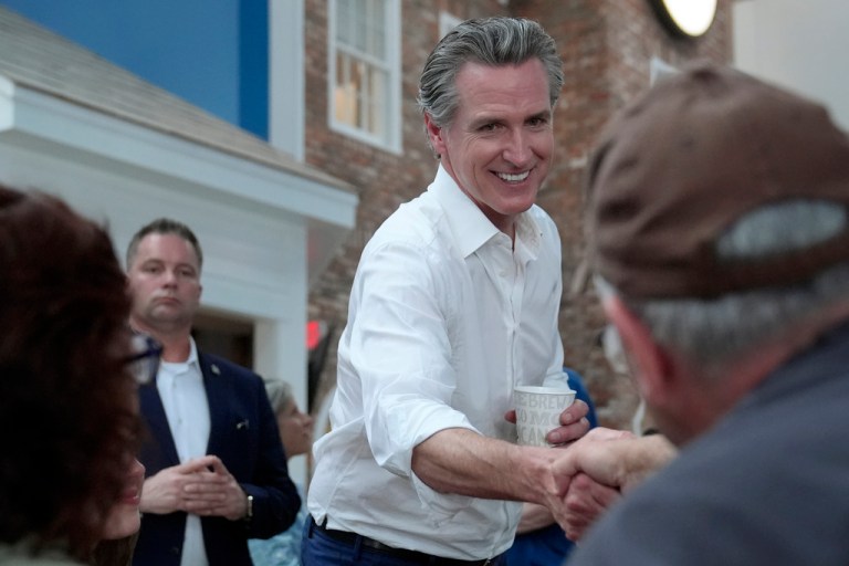 California Gov. Gavin Newsom, center, greets people, Monday, July 8, 2024, near the Common Man Roadside Market and Deli, in Hooksett, N.H. (AP Photo/Steven Senne)