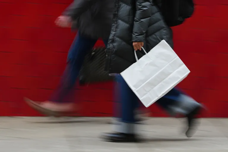 FILE - A person carries a shopping bag in Philadelphia, Wednesday, Dec. 10, 2025.
