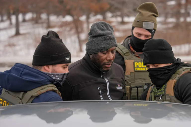 Immigration and Customs Enforcement (ICE) agents detain a man, second from left, during a traffic stop, Sunday, Jan. 11, 2026, in Robbinsdale, Minn. (AP Photo/John Locher)