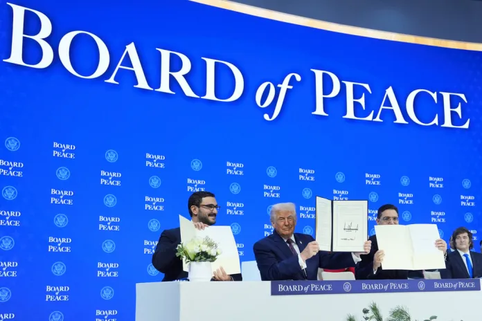 President Donald Trump, center, holds up a signed Board of Peace charter during the Annual Meeting of the World Economic Forum in Davos, Switzerland.