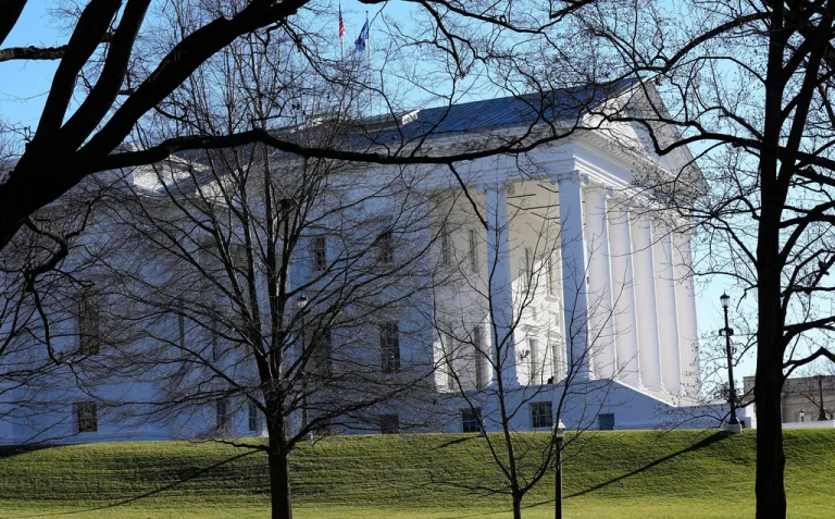 The state and U.S. flags fly over the Virginia State Capitol.