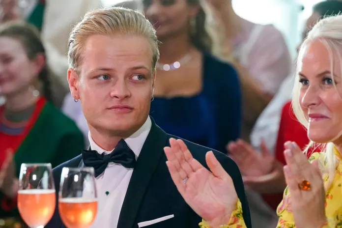 Marius Borg Hoiby sits with his mother, Mette-Marit, at a formal event