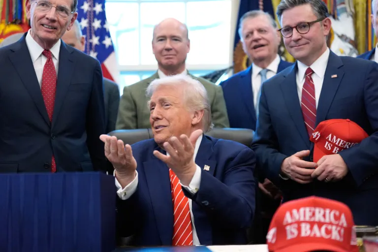 President Donald Trump speaks to reporters with hands up near his head after signing a spending bill that ends a partial shutdown of the federal government in the Oval Office of the White House, Tuesday, Feb. 3, 2026, in Washington. (AP Photo/Alex Brandon)
