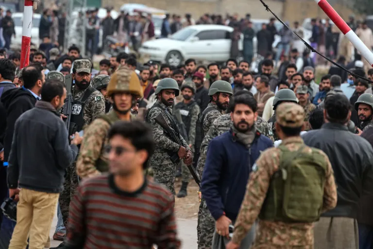 Pakistani paramilitary soldiers control a crowd close to the site of a bomb explosion at a Shiite mosque in Islamabad, Pakistan.