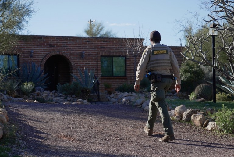 A member of the Pima County sheriffs office remains outside of Nancy Guthrie's home.