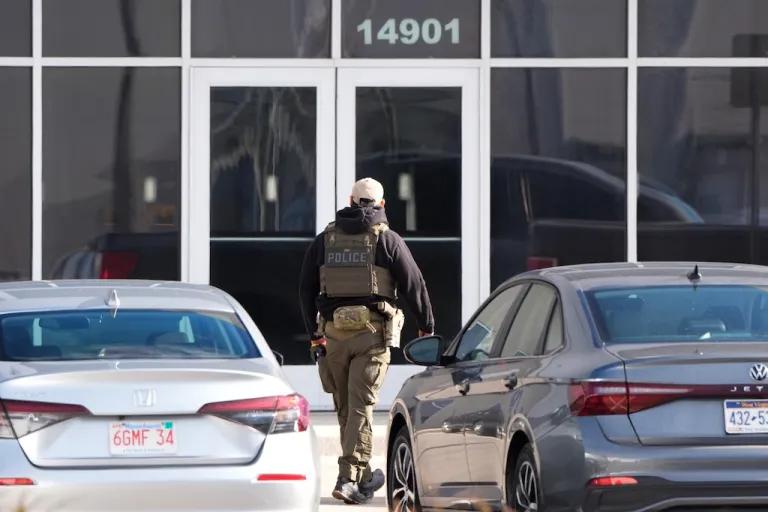 An ICE officer stands outside a warehouse as federal officials tour the facility to consider repurposing it as an ICE detention facility, Jan. 15, 2026, in Kansas City, Mo. (AP Photo/Charlie Riedel, file)