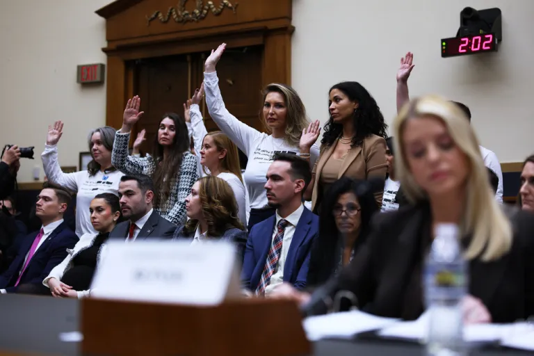 Attorney General Pam Bondi refuses to acknowledge the survivors raising their hands behind her as she testifies before a House Judiciary Committee oversight hearing on Capitol Hill in Washington, Feb. 11, 2026, in front of survivors of convicted sex offender Jeffrey Epstein. (AP Photo/Tom Brenner, File)