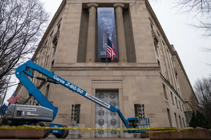 A banner showing President Donald Trump is hung from the Department of Justice.