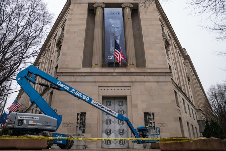 A banner showing President Donald Trump is hung from the Department of Justice.