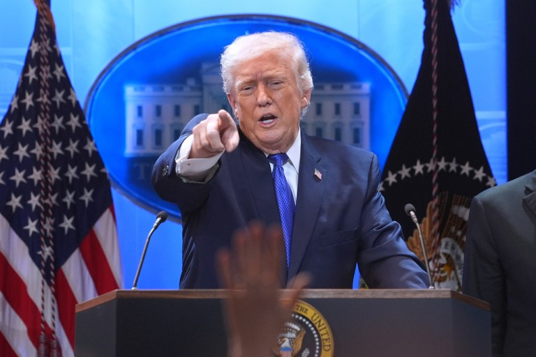 President Donald Trump points to a reporter during a press briefing at the White House.