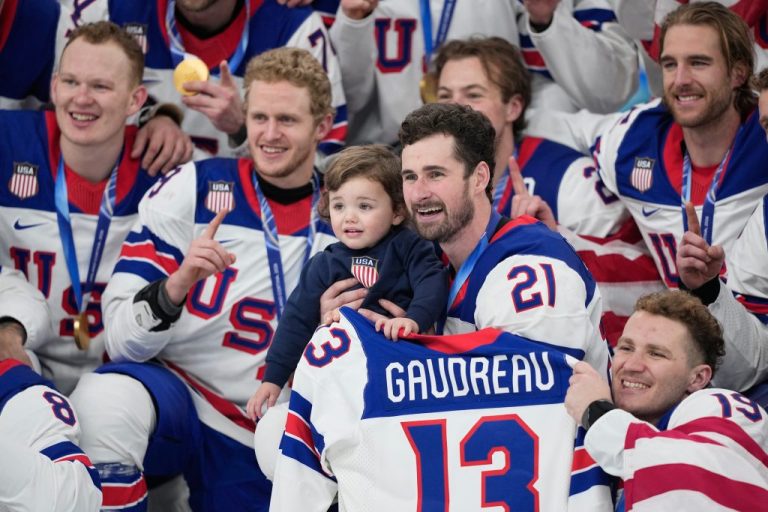United States' Dylan Larkin (21) holds Johnny, the son of the late player Johnny Gaudreau