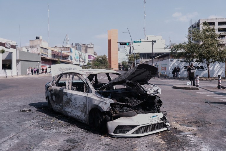 A vehicle sits charred after being set on fire, on a road in Guadalajara, Jalisco state, Mexico, Sunday, Feb. 22, 2026, after the death of the leader of the Jalisco New Generation Cartel, Nemesio Rubén Oseguera Cervantes, known as
