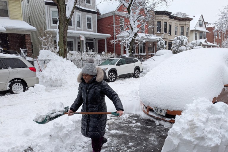 Christa Prince shovels snow during a blizzard in Brooklyn, New York, on Monday, Feb. 23, 2026. (AP Photo/Drew Callister)