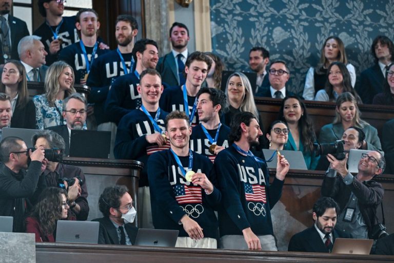 Olympic men's hockey team standing together for pictures with their medals at Trump's State of the Union.