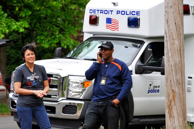 Detroit Police officers Wendy Flanagan and Todd Bettison stand in front of an RV.