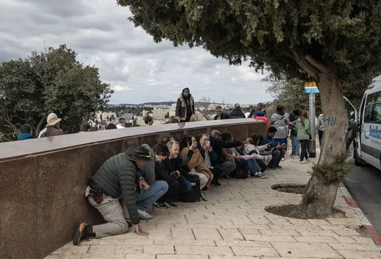 People take shelter as Iran launched missiles and drones towards Israel following the US-Israeli attacks, in Jerusalem on February 28, 2026. Israeli air defence systems destroyed some of the missiles launched by Iran, as sirens are heard in the city. (Photo by Mostafa Alkharouf/Anadolu via Getty Images)