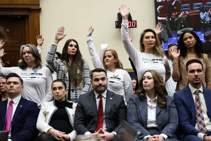 Accusers of convicted sex offender Jeffrey Epstein raise their hands during Attorney General Pam Bondi's testimony before the House Judiciary Committee.