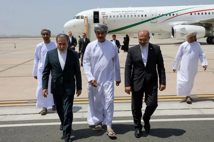 In this photo released by the Iranian Foreign Ministry, Iranian Foreign Minister Abbas Araghchi, left, is welcomed by an unidentified Omani official, center, upon his arrival at Muscat, Oman, for negotiations with U.S. Mideast envoy Steve Witkoff, as Iranian Ambassador to Oman Mousa Farhang walks at right, May 11, 2025. (Iranian Foreign Ministry via AP, File)