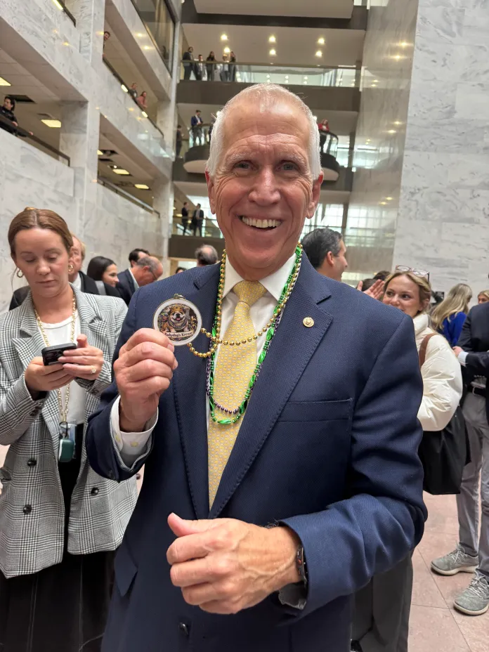 Sen. Thom Tillis (R-NC) shows off a Babydog necklace complete with a medallion imprinted with her face. (David Sivak/Washington Examiner)