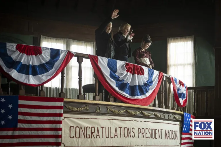 At Tomlinson's Hotel, James Madison (Russel Bentley) wins the election, accompanied by Dolley Madison (Gemma Acosta) and Thomas Jefferson (Mark Gillis), in Fox Nation's new series, 