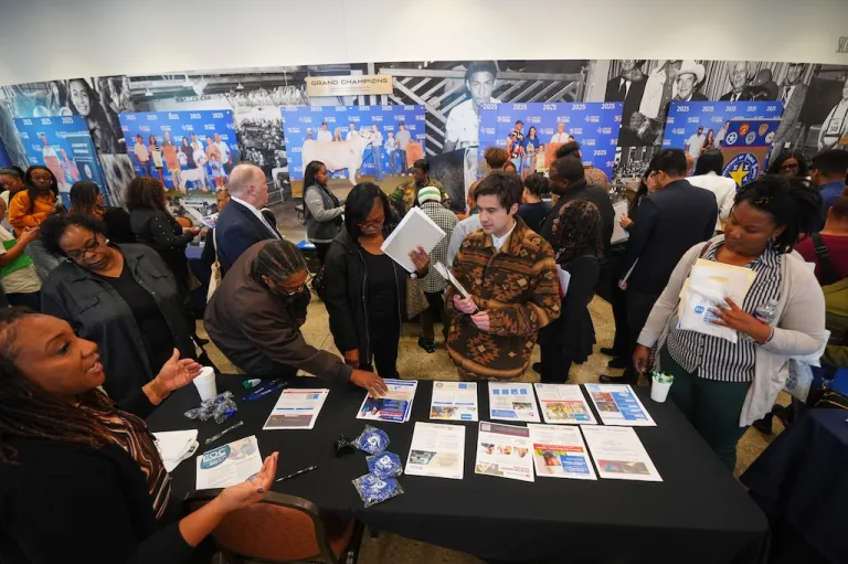 Job seekers listen for information on employment during a hiring fair at Fair Park in Dallas.