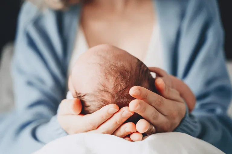 Newborn in mother's hands.