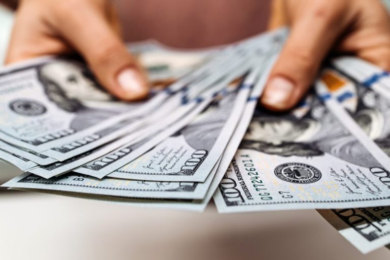 Someone fanning out their deck of 100 dollar bills. money, cash, paychecks, inflation, wages