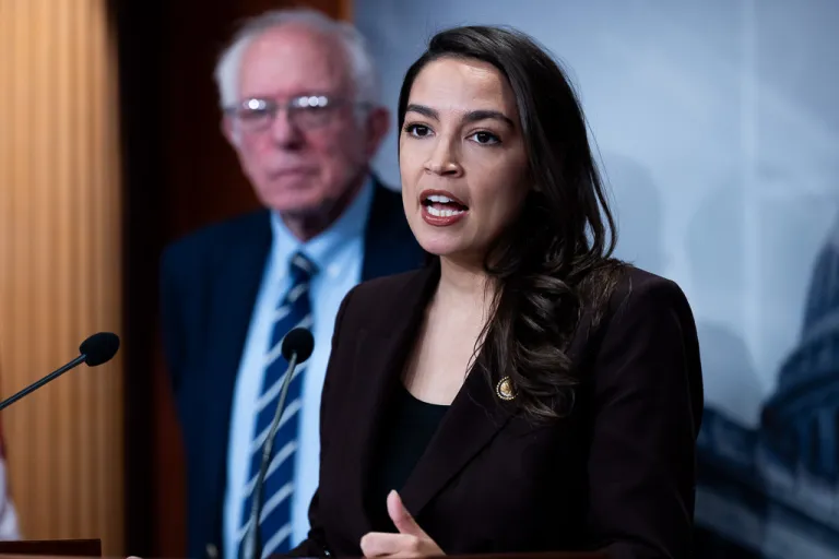 Rep. Alexandria Ocasio-Cortez (D-NY) speaks alongside Sen. Bernie Sanders (I-VT) at a press conference.