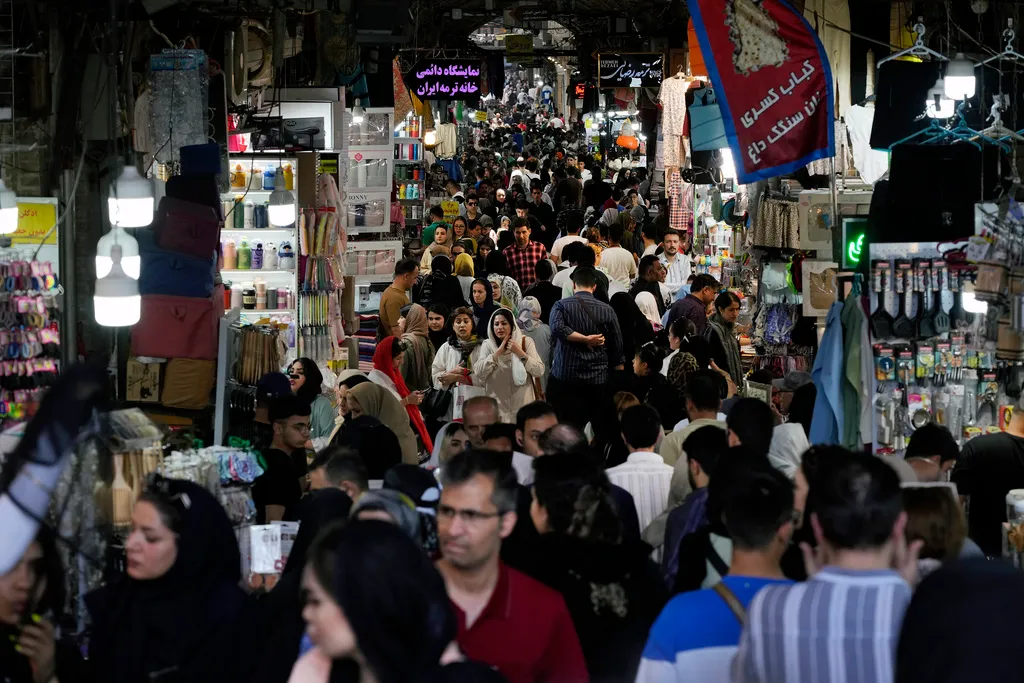 People walk through the old main bazaar of Tehran, Iran, Thursday, June 13, 2024. 