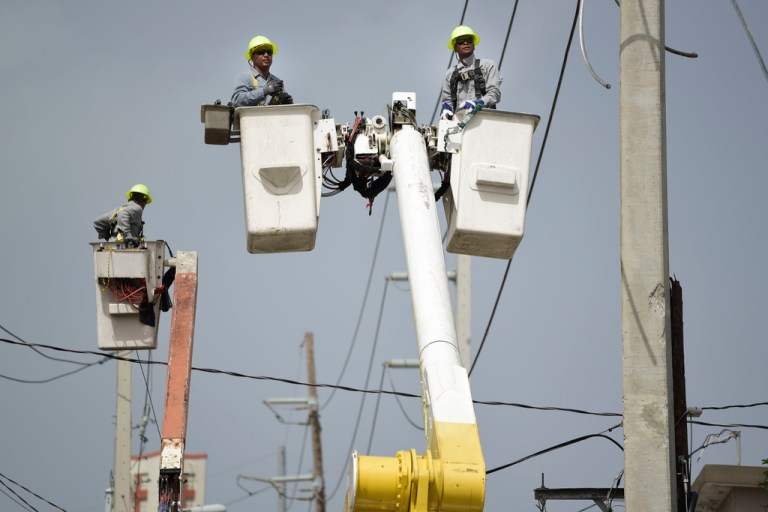 FILE - Puerto Rico Electric Power Authority workers repair distribution lines damaged by Hurricane Maria in the Cantera community of San Juan, Puerto Rico, Oct. 19, 2017. The private operator of Puerto Rico’s power grid confirmed Monday, June 24, 2024, the deferral of $65 million worth of maintenance and improvement projects in the U.S. territory, with some repairs postponed for at least a year because of budget constraints. (AP Photo/Carlos Giusti, File)