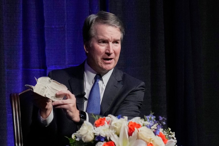 Justice Brett Kavanaugh holds his personal pocket constitution as he speaks at The Ken Starr Lecture at McLennan Community College, Thursday, Sept. 11, 2025, in Waco, Texas. (AP Photo/Tony Gutierrez)
