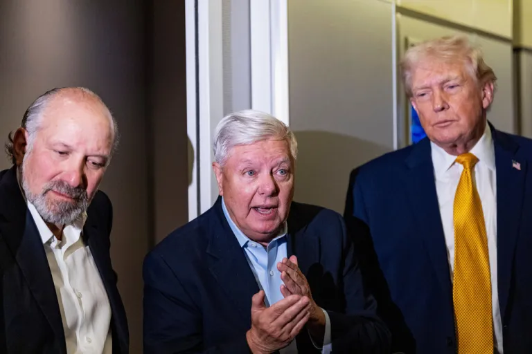 President Donald Trump, accompanied by Commerce Secretary Howard Lutnick, left, and Sen. Lindsey Graham, R-S.C., speaks with reporters while in flight on Air Force One, Sunday, Jan. 4, 2026, as returning to Joint Base Andrews, Md