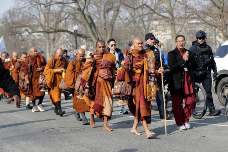 Police officers patrol with Buddhist monks.