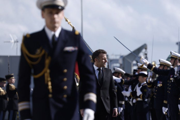 French President Emmanuel Macron inspects troops at Ile Longue.