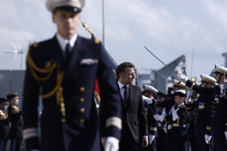 French President Emmanuel Macron inspects troops at Ile Longue.