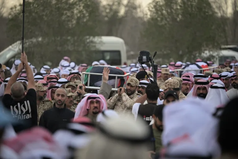 Kuwaitis carry the bodies of two soldiers killed by Iranian strikes.