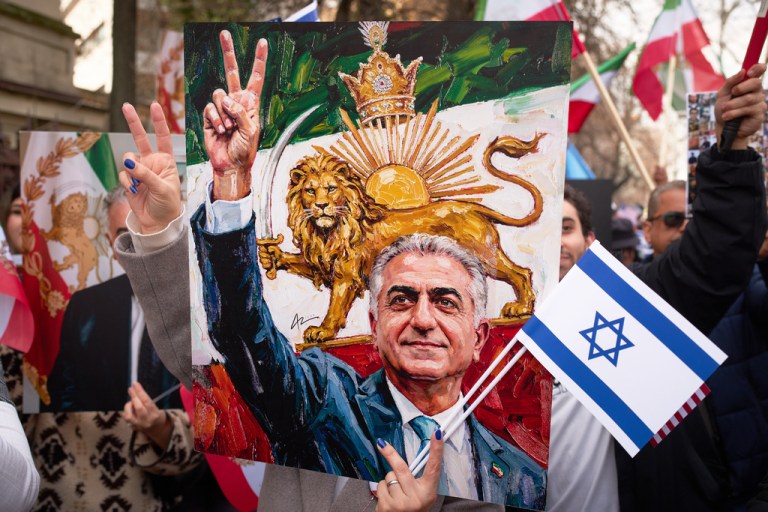 An poster shows a drawing of Reza Pahlvai flashing a victory gesture