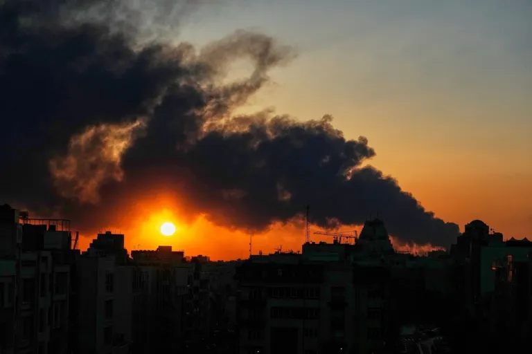 The sun sets behind a plume of smoke rising from a U.S.–Israeli military strike in Tehran, Iran, Tuesday, March 3, 2026. (AP Photo/Vahid Salemi)