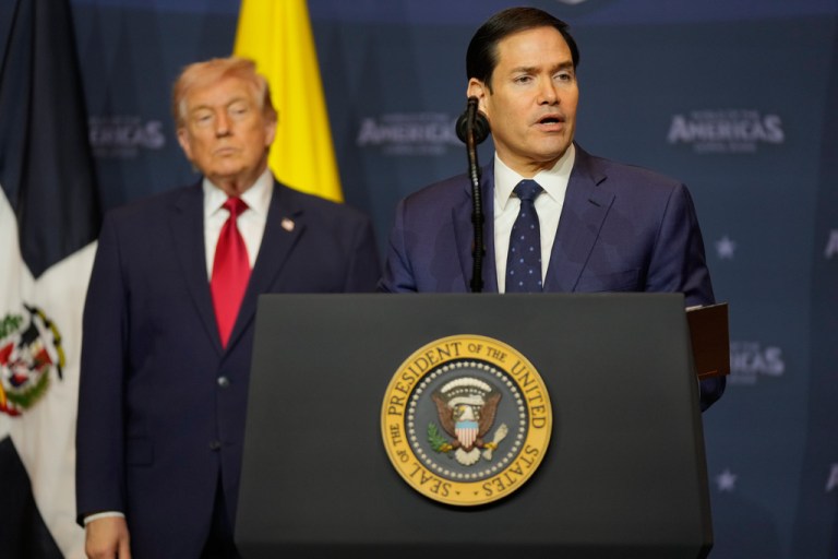 Secretary of State Marco Rubio speaks while President Donald Trump, left, listens during the Shield of the Americas Summit, Saturday, March 7, 2026, at Trump National Doral Miami in Doral, Fla.