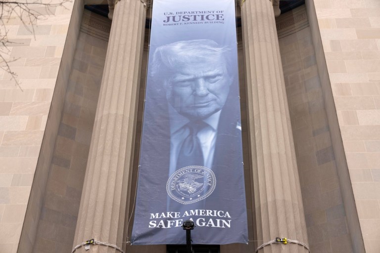 A banner with a portrait of President Donald Trump is hung from the Department of Justice, Thursday, March 5, 2026, in Washington. (AP Photo/Jose Luis Magana)