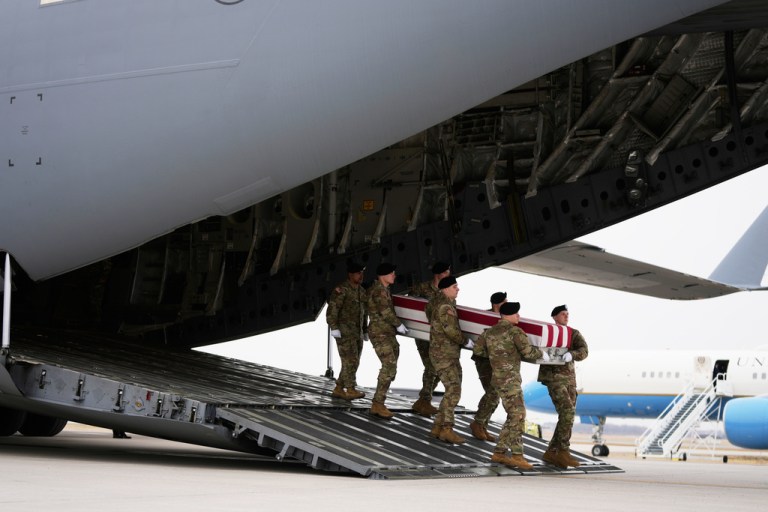 An Army carry team moves a flag-draped transfer case