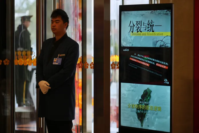 A monitor shows an image of Taiwan and the slogan "Division and Reunification"