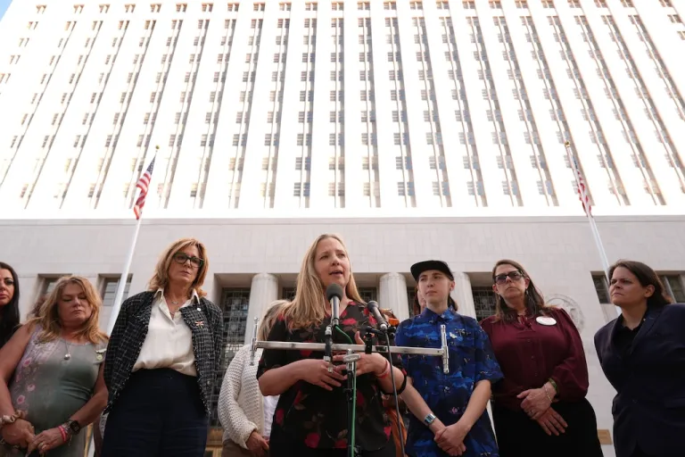 Amy Neville, at podium, whose son Alexander, 14, died after taking a pill bought on social media which was laced with fentanyl, speaks to media surrounded by other parents outside Los Angeles Superior Court on Thursday, March 12, 2026, in Los Angeles. (AP Photo/Damian Dovarganes)