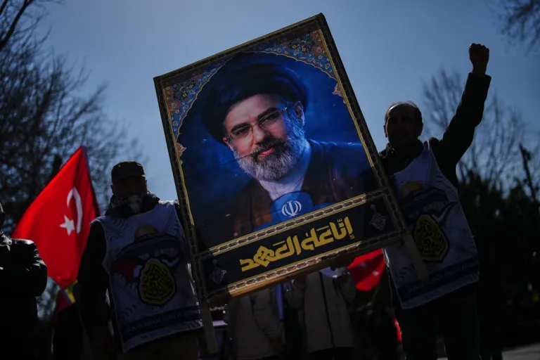 People hold a portrait of new Iranian Ayatollah Mojtaba Khamenei.